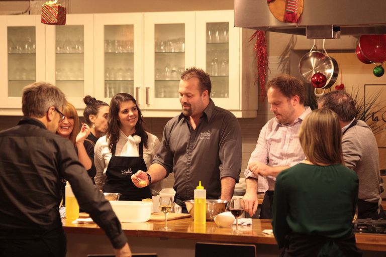 a group of people preparing food in a commercial kitchen